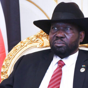 Salva Kiir assis devant les couleurs du Soudan du Sud.