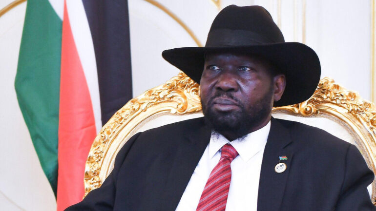 Salva Kiir assis devant les couleurs du Soudan du Sud.