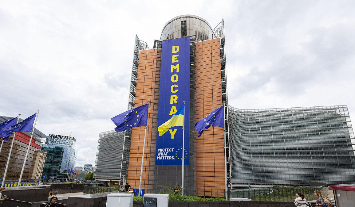 Bâtiment de la Commission européenne à Bruxelles avec des drapeaux européens.