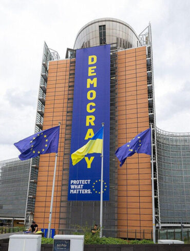 Bâtiment de la Commission européenne à Bruxelles avec des drapeaux européens.