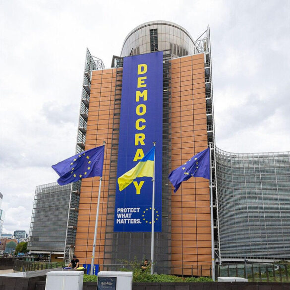 Bâtiment de la Commission européenne à Bruxelles avec des drapeaux européens.